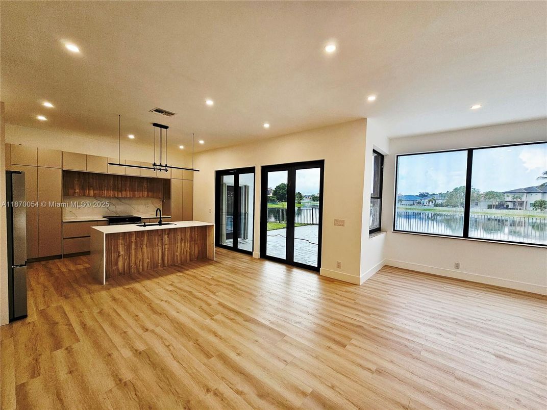 Empty room, Interior, Kitchen, Pendant Lights, Recessed Lighting, Stainless Steel Appliances, Water, Wood Texture Flooring