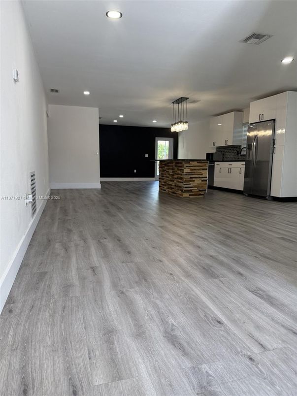 Empty room, Interior, Kitchen, Pendant Lights, Recessed Lighting, Stainless Steel Appliances, Wood Texture Flooring