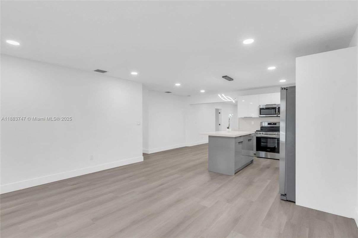 Empty room, Interior, Kitchen, Recessed Lighting, Stainless Steel Appliances, Wood Texture Flooring