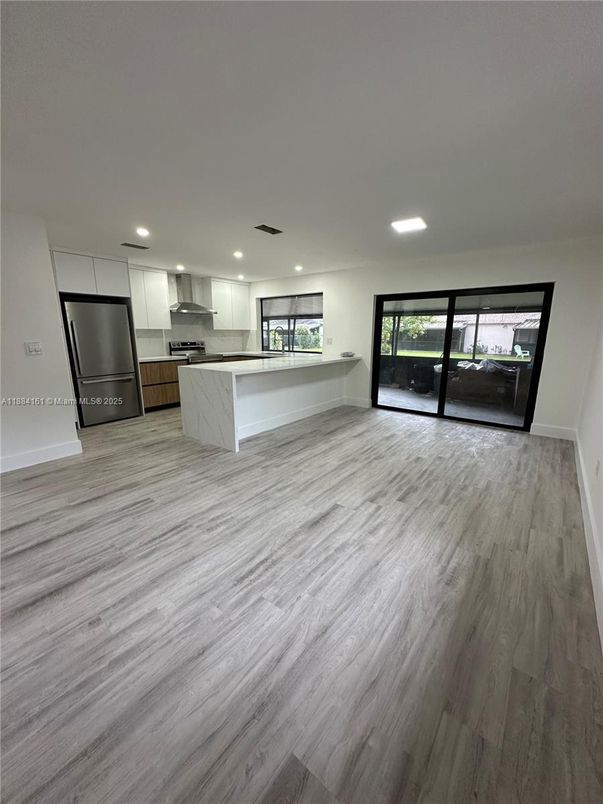 Empty room, Interior, Kitchen, Recessed Lighting, Stainless Steel Appliances, Wood Texture Flooring