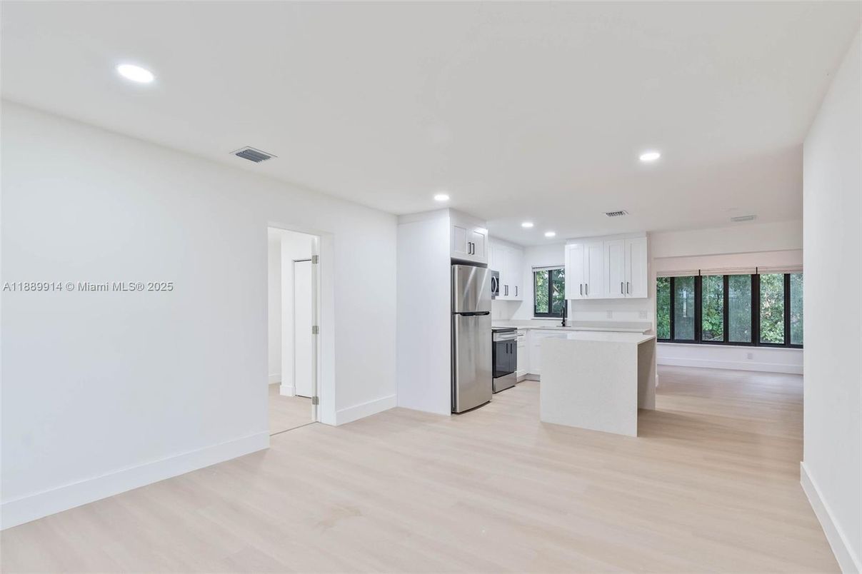 Empty room, Interior, Kitchen, Recessed Lighting, Stainless Steel Appliances, Wood Texture Flooring
