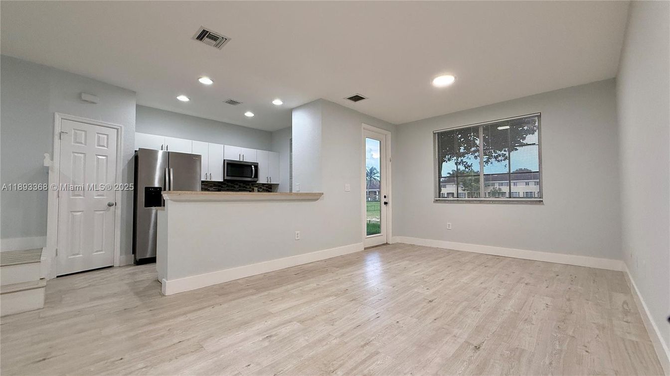 Empty room, Interior, Kitchen, Recessed Lighting, Stainless Steel Appliances, Wood Texture Flooring