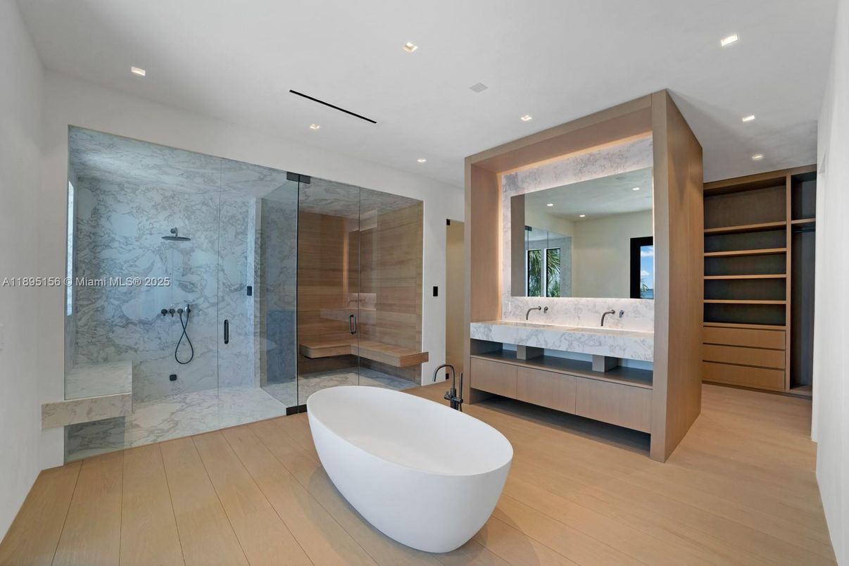 Bathroom, Dual Sink Vanities, Free Standing Baths, Glass Shower, Interior, Marble Walls, Recessed Lighting, Wood Texture Flooring