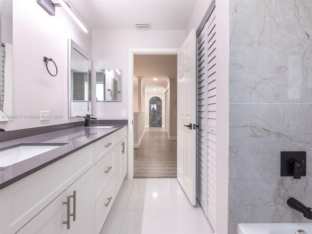Bathroom, Dual Sink Vanities, Interior, Marble, Marble Walls, Recessed Lighting, Wood Texture Flooring