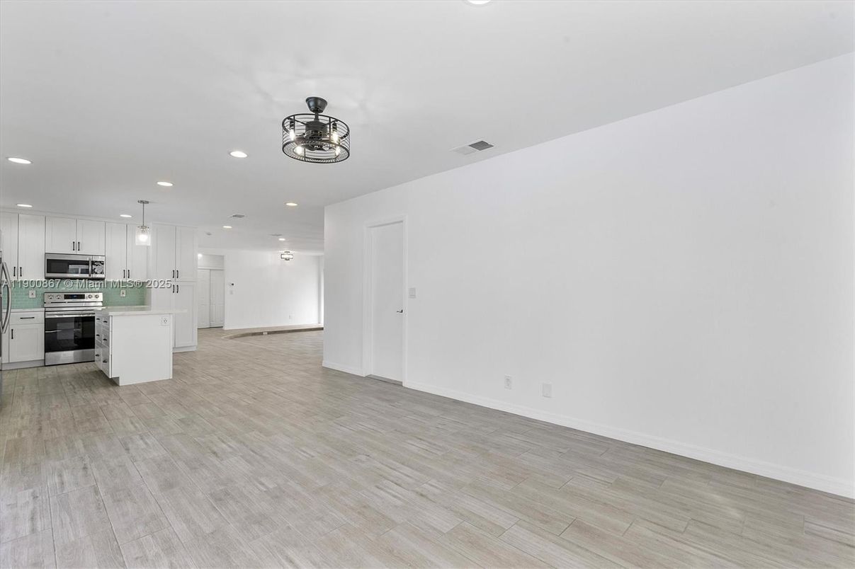 Empty room, Interior, Kitchen, Pendant Lights, Recessed Lighting, Stainless Steel Appliances, Wood Texture Flooring