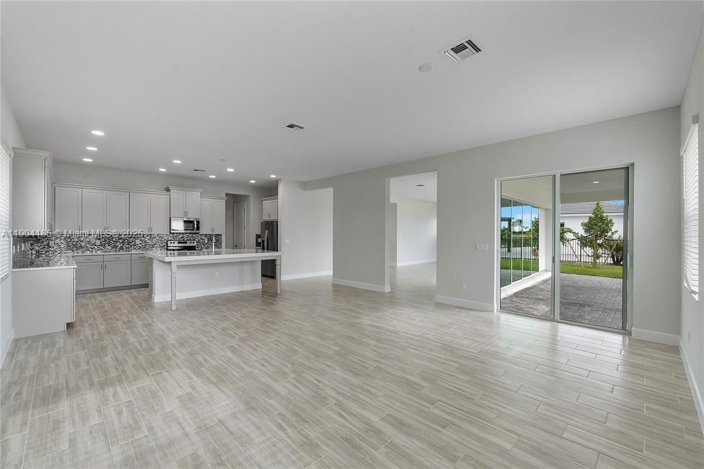 Empty room, Interior, Kitchen, Recessed Lighting, Stainless Steel Appliances, Wood Texture Flooring