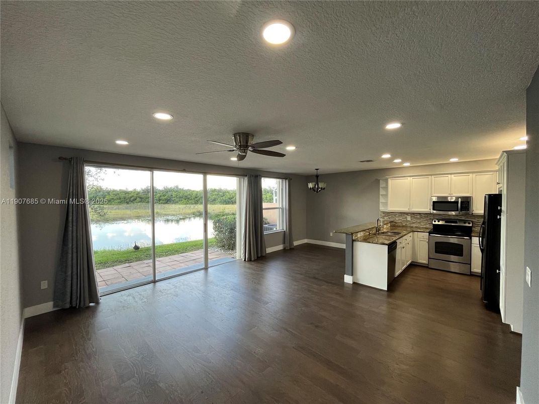 Empty room, Interior, Kitchen, Recessed Lighting, Stainless Steel Appliances, Water, Wood Texture Flooring