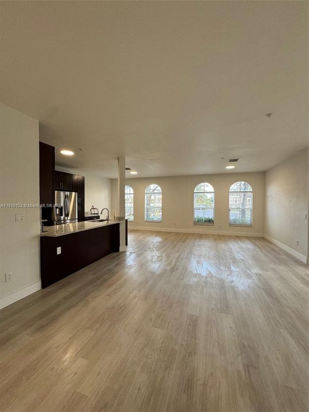Empty room, Interior, Kitchen, Recessed Lighting, Stainless Steel Appliances, Wood Texture Flooring