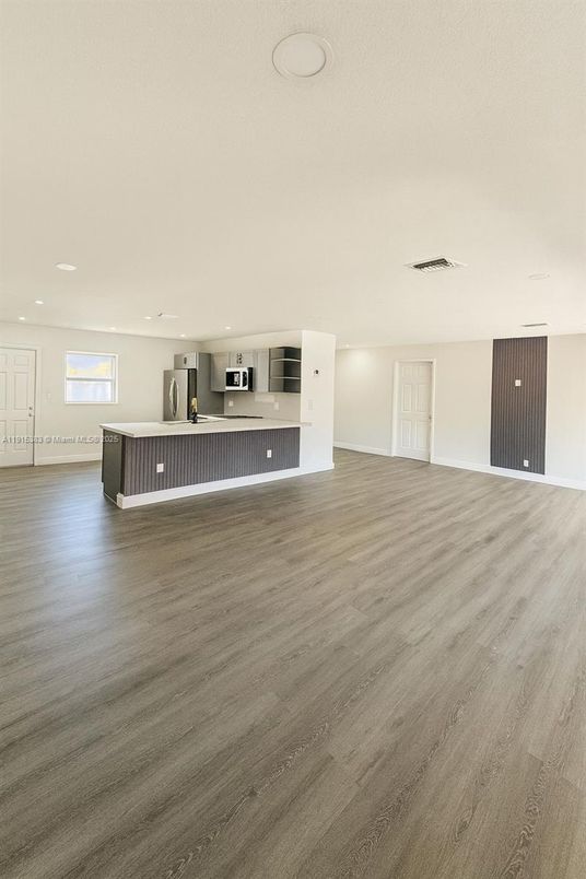 Empty room, Interior, Kitchen, Recessed Lighting, Stainless Steel Appliances, Wood Texture Flooring