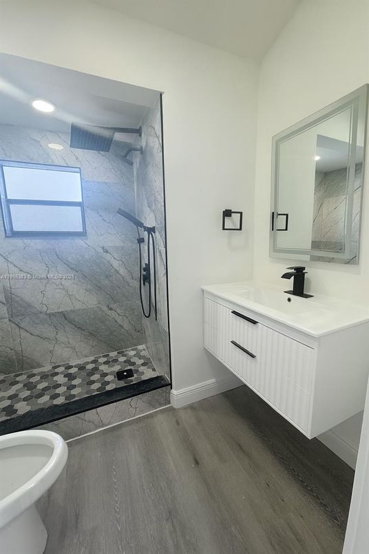 Bathroom, Dual Sink Vanities, Glass Shower, Interior, Marble Walls, Recessed Lighting, Wood Texture Flooring