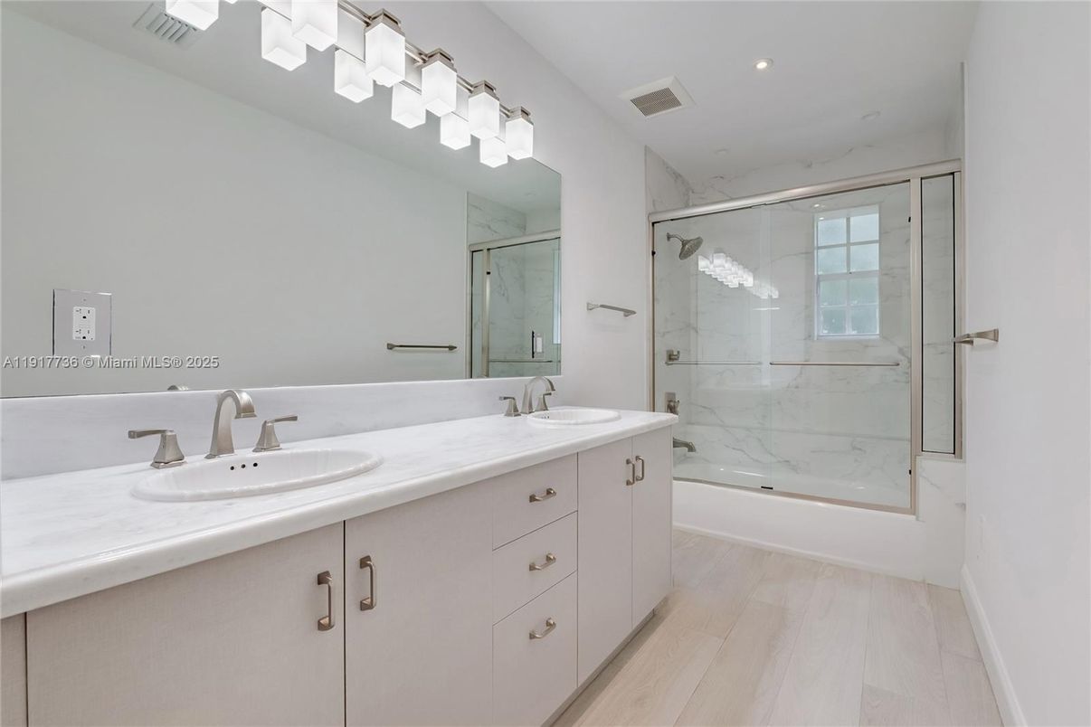 Bathroom, Dual Sink Vanities, Glass Shower, Interior, Marble Walls, Recessed Lighting, Wood Texture Flooring