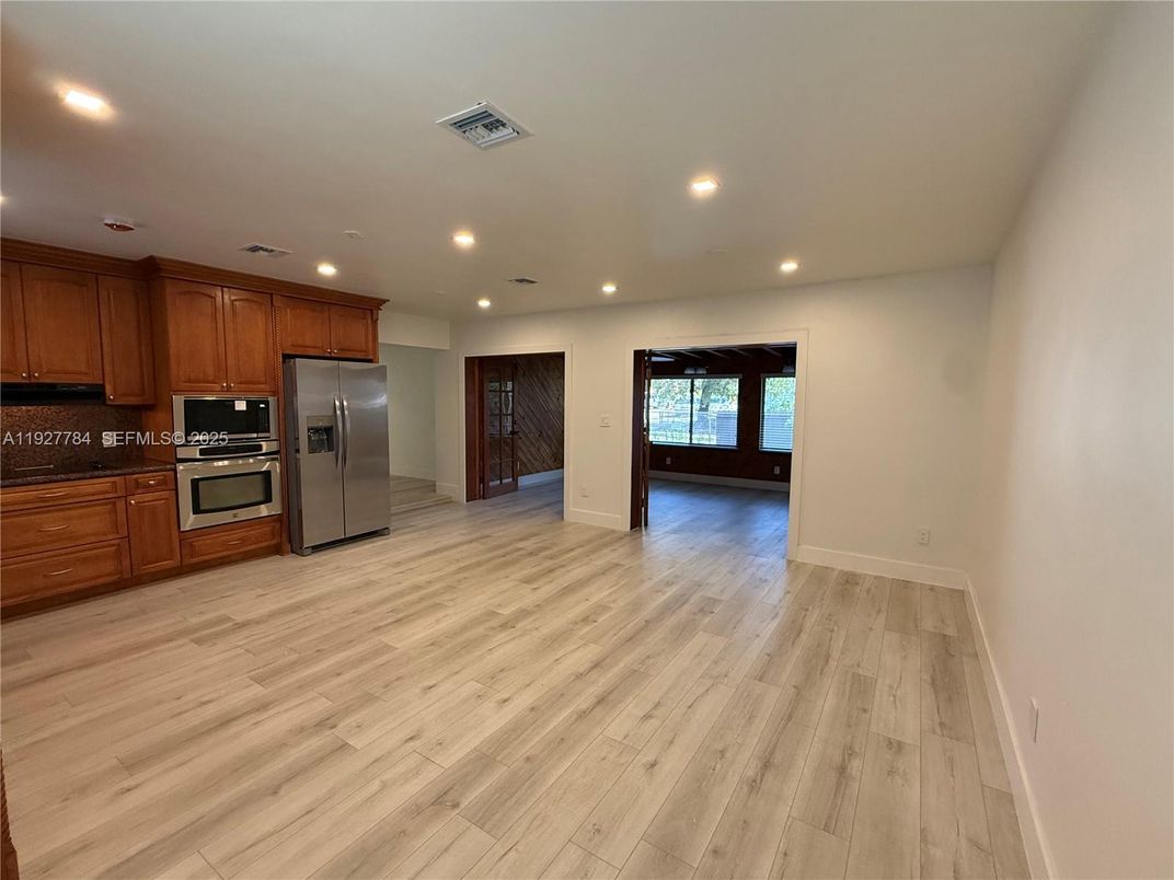 Empty room, Interior, Kitchen, Recessed Lighting, Stainless Steel Appliances, Wood Texture Flooring