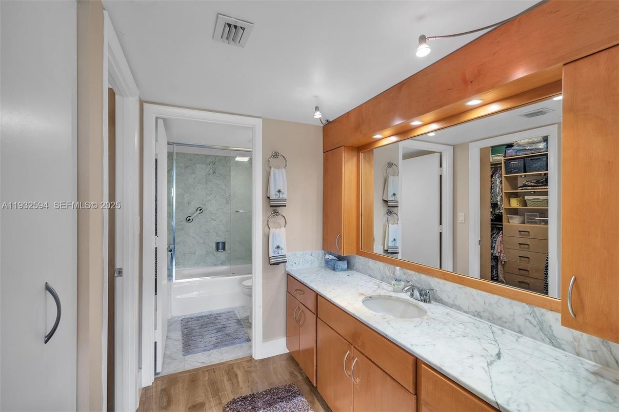Bathroom, Dual Sink Vanities, Glass Shower, Interior, Marble, Marble Walls, Recessed Lighting, Wood Texture Flooring