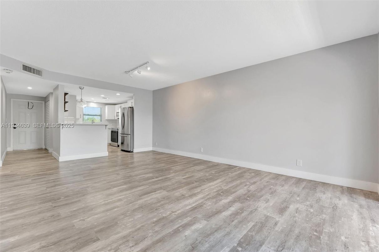 Empty room, Interior, Kitchen, Recessed Lighting, Stainless Steel Appliances, Wood Texture Flooring