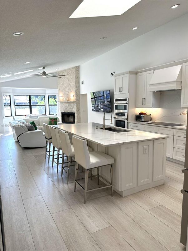 Fireplace, Interior, Kitchen, Living room, Recessed Lighting, Stainless Steel Appliances, Stone Walls, Wood Texture Flooring