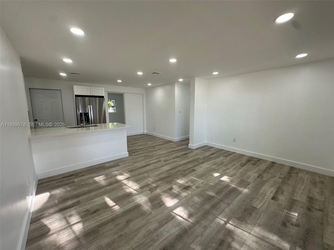 Empty room, Interior, Kitchen, Recessed Lighting, Stainless Steel Appliances, Wood Texture Flooring