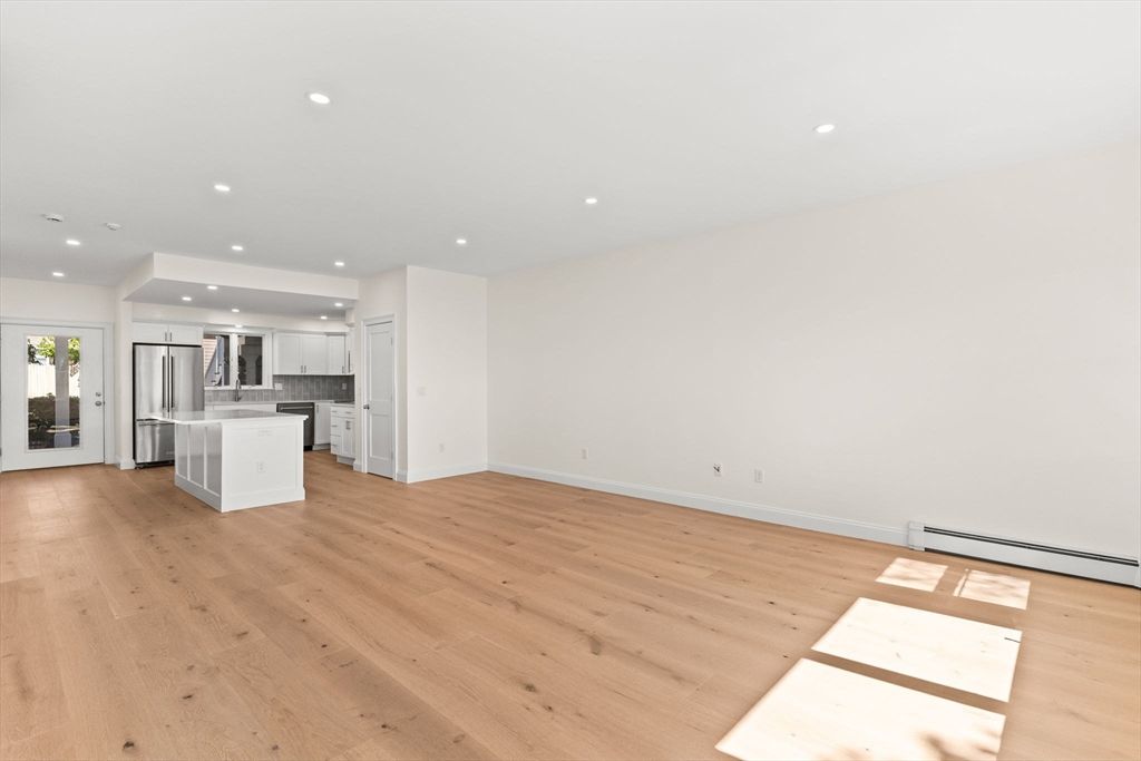Empty room, Interior, Kitchen, Recessed Lighting, Stainless Steel Appliances, Wood Texture Flooring