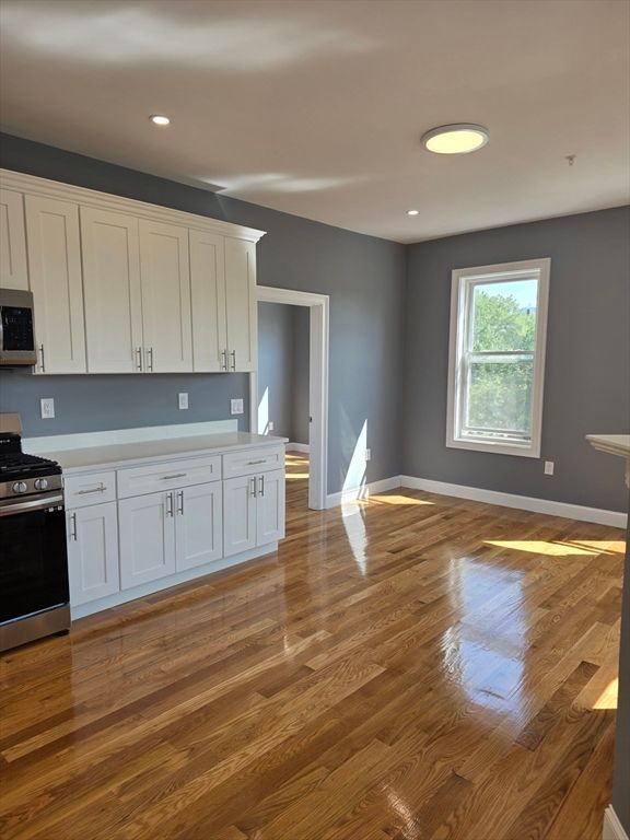 Empty room, Interior, Kitchen, Recessed Lighting, Stainless Steel Appliances, Wood Texture Flooring