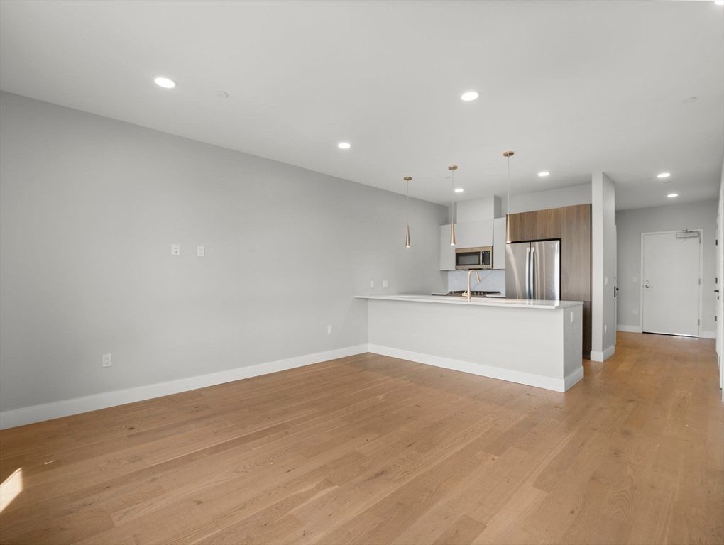 Empty room, Interior, Kitchen, Pendant Lights, Recessed Lighting, Stainless Steel Appliances, Wood Texture Flooring