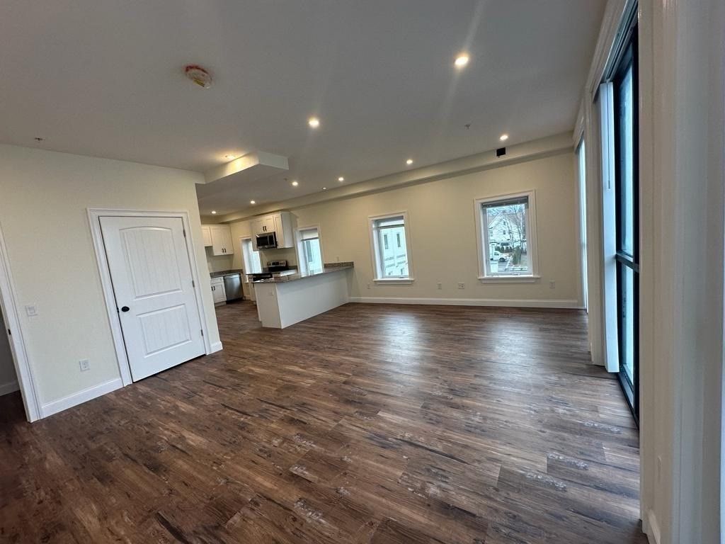 Empty room, Interior, Kitchen, Recessed Lighting, Stainless Steel Appliances, Wood Texture Flooring