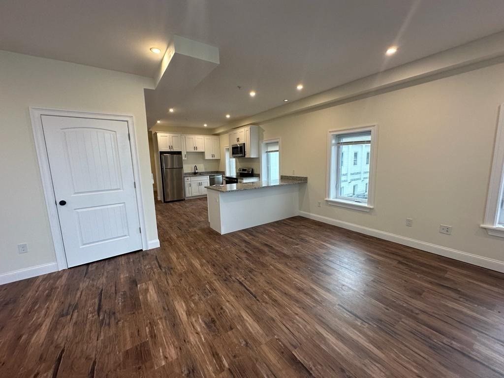 Empty room, Interior, Kitchen, Recessed Lighting, Stainless Steel Appliances, Wood Texture Flooring