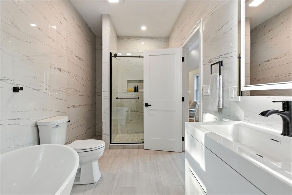 Bathroom, Dual Sink Vanities, Glass Shower, Interior, Marble Walls, Recessed Lighting, Wood Texture Flooring