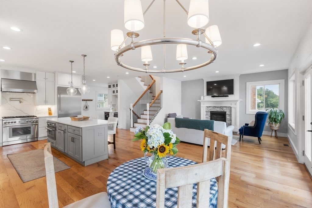Chandelier, Fireplace, Interior, Kitchen, Living room, Pendant Lights, Recessed Lighting, Stainless Steel Appliances, Wood Texture Flooring