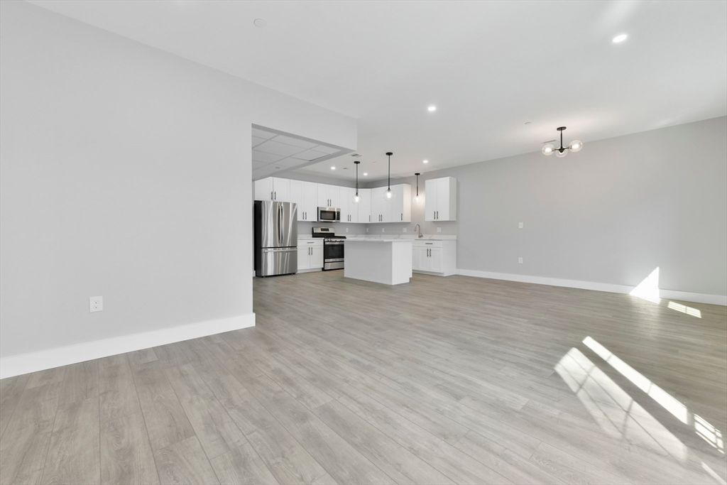 Empty room, Interior, Kitchen, Pendant Lights, Recessed Lighting, Stainless Steel Appliances, Wood Texture Flooring