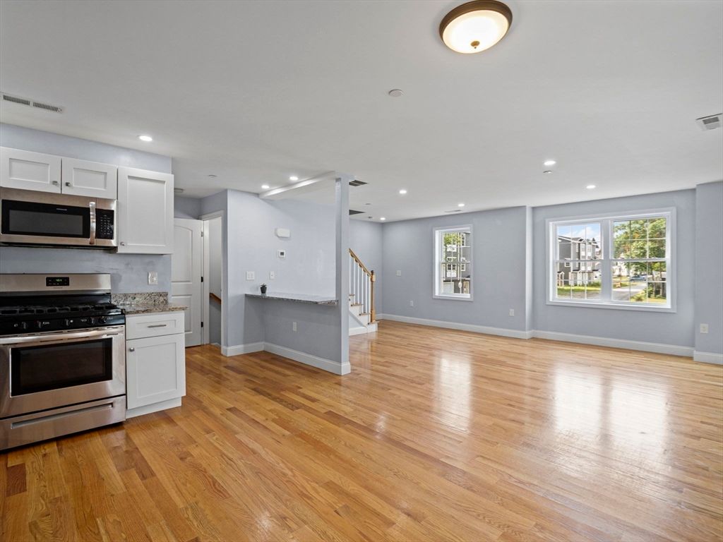 Empty room, Interior, Kitchen, Recessed Lighting, Stainless Steel Appliances, Wood Texture Flooring