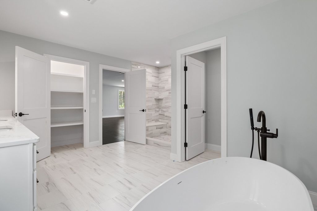 Bathroom, Dual Sink Vanities, Free Standing Baths, Interior, Marble, Marble Walls, Recessed Lighting, Wood Texture Flooring
