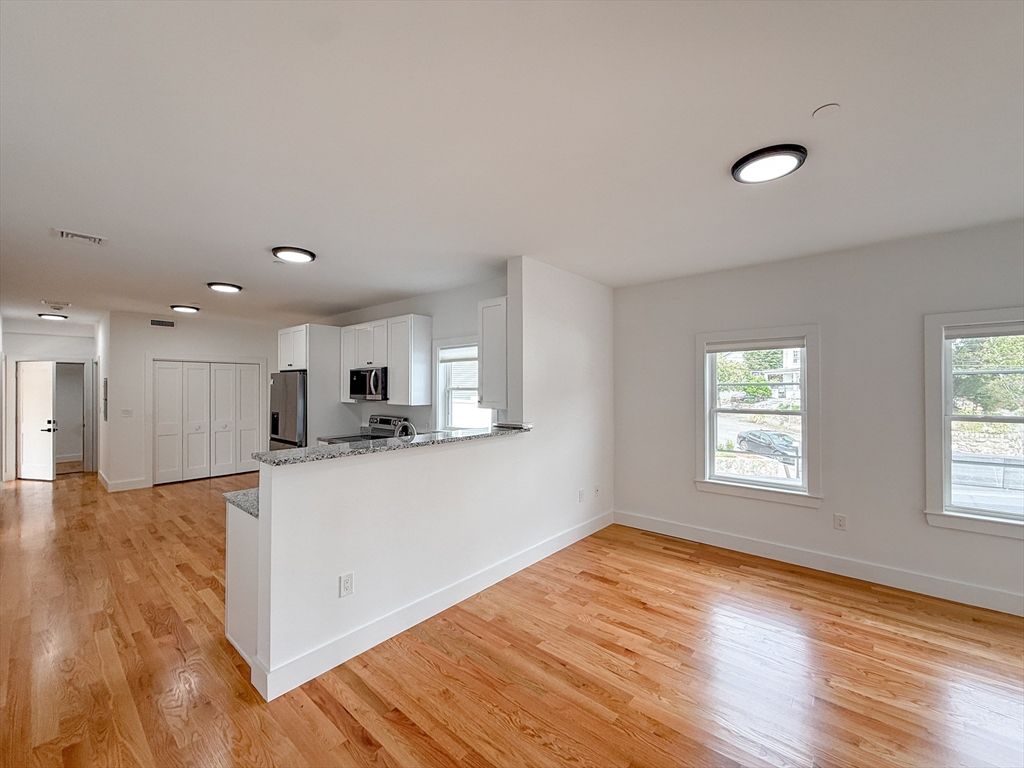 Empty room, Interior, Kitchen, Recessed Lighting, Stainless Steel Appliances, Wood Texture Flooring