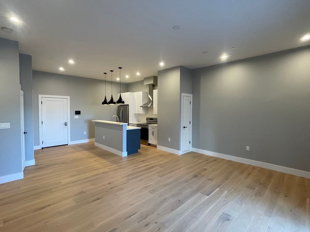 Empty room, Interior, Kitchen, Pendant Lights, Recessed Lighting, Stainless Steel Appliances, Wood Texture Flooring