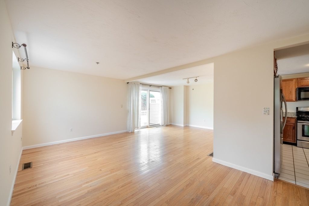 Empty room, Interior, Kitchen, Recessed Lighting, Stainless Steel Appliances, Wood Texture Flooring