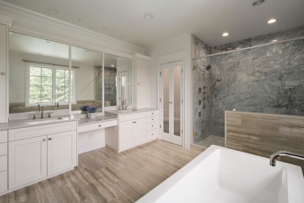 Bathroom, Dual Sink Vanities, Free Standing Baths, Glass Shower, Interior, Marble Walls, Recessed Lighting, Wood Texture Flooring