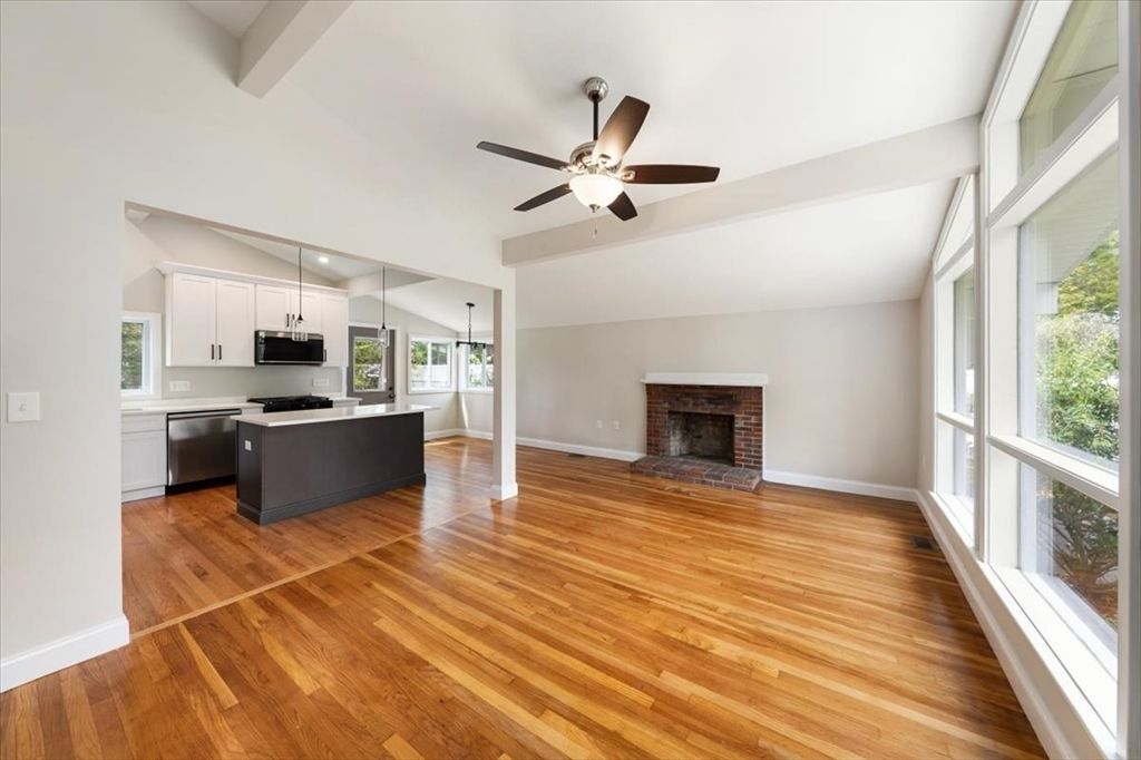 Empty room, Fireplace, Interior, Kitchen, Pendant Lights, Stainless Steel Appliances, Wood Texture Flooring