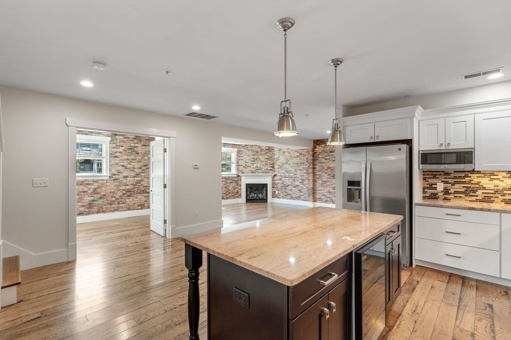 Fireplace, Interior, Kitchen, Pendant Lights, Recessed Lighting, Stainless Steel Appliances, Stone Walls, Wood Texture Flooring
