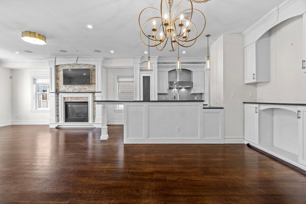 Chandelier, Empty room, Fireplace, Interior, Kitchen, Recessed Lighting, Stainless Steel Appliances, Wood Texture Flooring