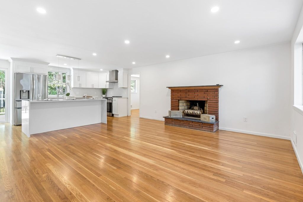 Empty room, Fireplace, Interior, Kitchen, Recessed Lighting, Stainless Steel Appliances, Wood Texture Flooring