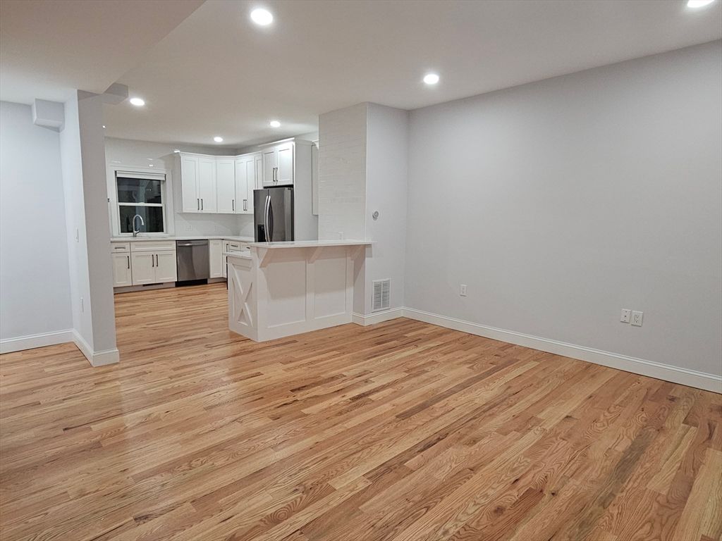 Empty room, Interior, Kitchen, Recessed Lighting, Stainless Steel Appliances, Wood Texture Flooring