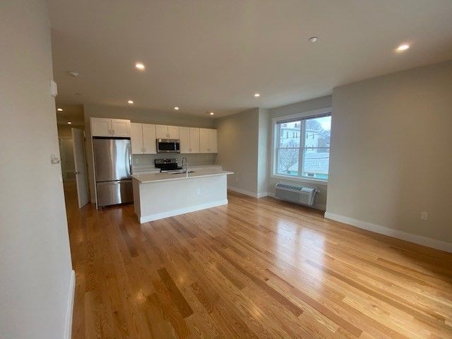 Empty room, Interior, Kitchen, Recessed Lighting, Stainless Steel Appliances, Wood Texture Flooring