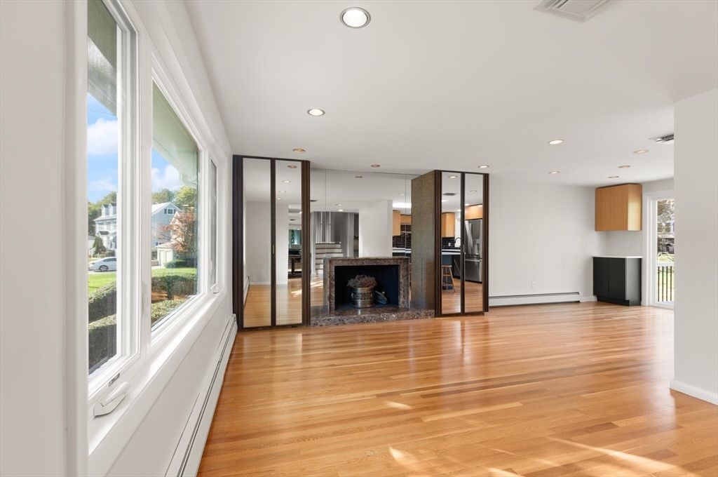 Empty room, Fireplace, Interior, Kitchen, Recessed Lighting, Stainless Steel Appliances, Wood Texture Flooring
