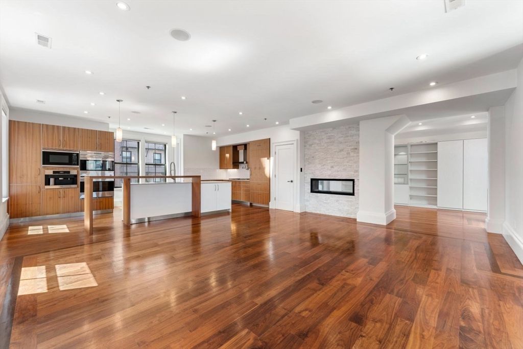 Empty room, Fireplace, Interior, Kitchen, Pendant Lights, Recessed Lighting, Stainless Steel Appliances, Stone Walls, Wood Texture Flooring