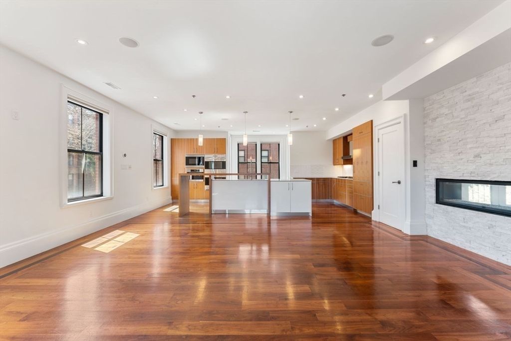 Empty room, Fireplace, Interior, Kitchen, Pendant Lights, Recessed Lighting, Stainless Steel Appliances, Stone Walls, Wood Texture Flooring