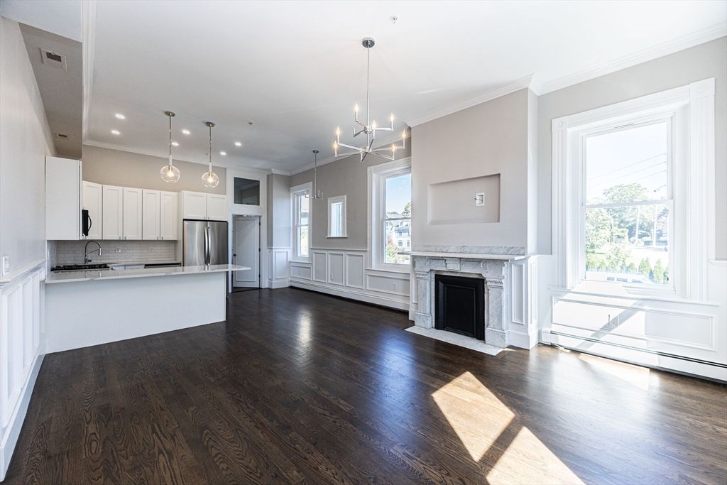 Empty room, Fireplace, Interior, Kitchen, Pendant Lights, Recessed Lighting, Stainless Steel Appliances, Wood Texture Flooring