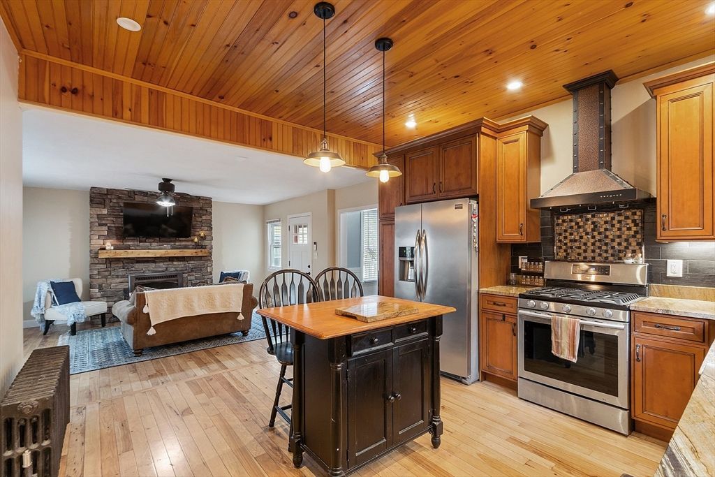 Fireplace, Interior, Kitchen, Living room, Pendant Lights, Recessed Lighting, Stainless Steel Appliances, Stone Walls, Wooden Ceilings, Wood Texture Flooring