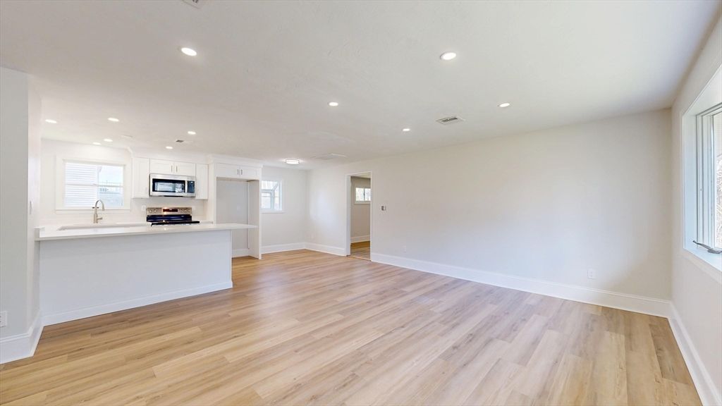 Empty room, Interior, Kitchen, Recessed Lighting, Stainless Steel Appliances, Wood Texture Flooring