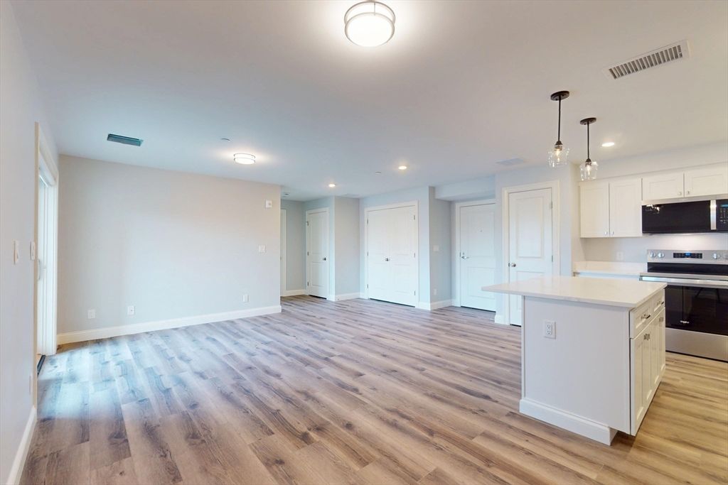 Empty room, Interior, Kitchen, Pendant Lights, Recessed Lighting, Stainless Steel Appliances, Wood Texture Flooring
