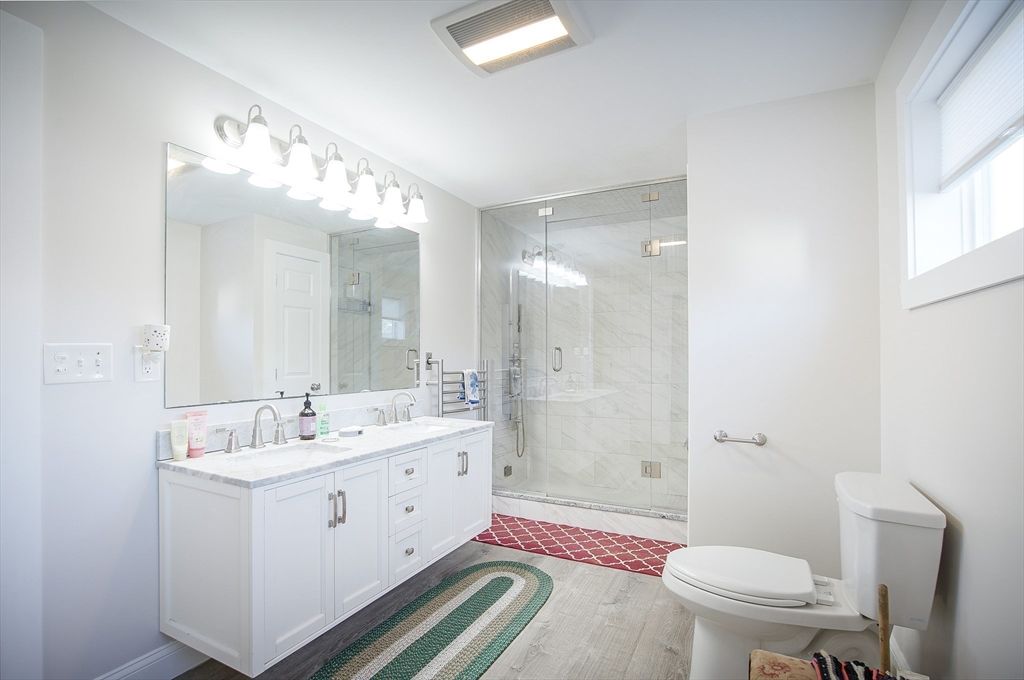 Bathroom, Dual Sink Vanities, Glass Shower, Interior, Marble Walls, Wood Texture Flooring