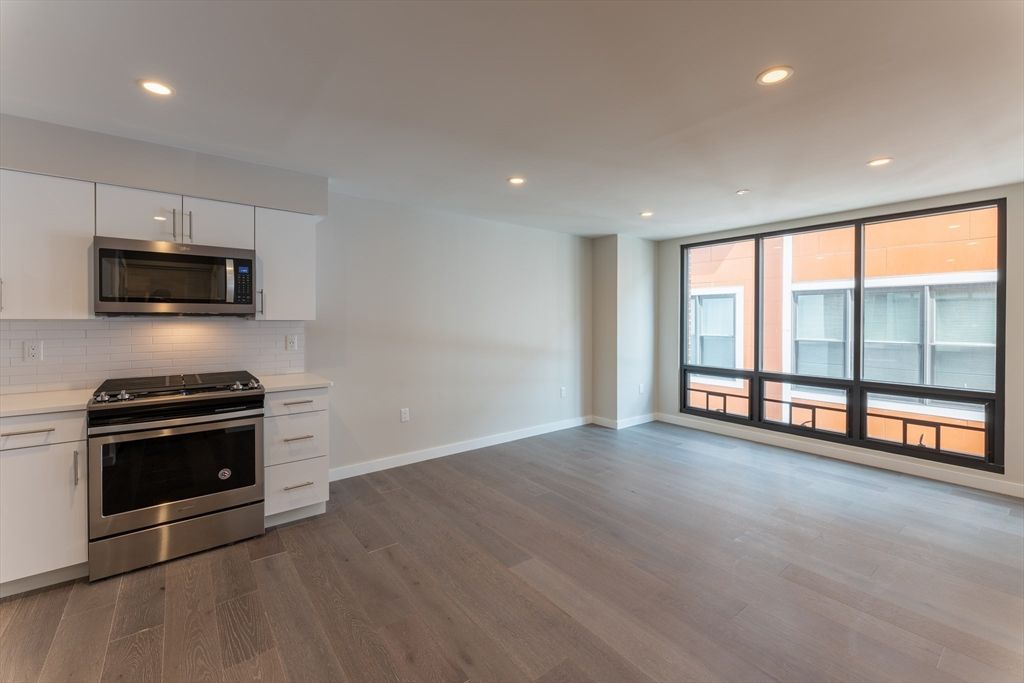 Empty room, Interior, Kitchen, Recessed Lighting, Stainless Steel Appliances, Wood Texture Flooring