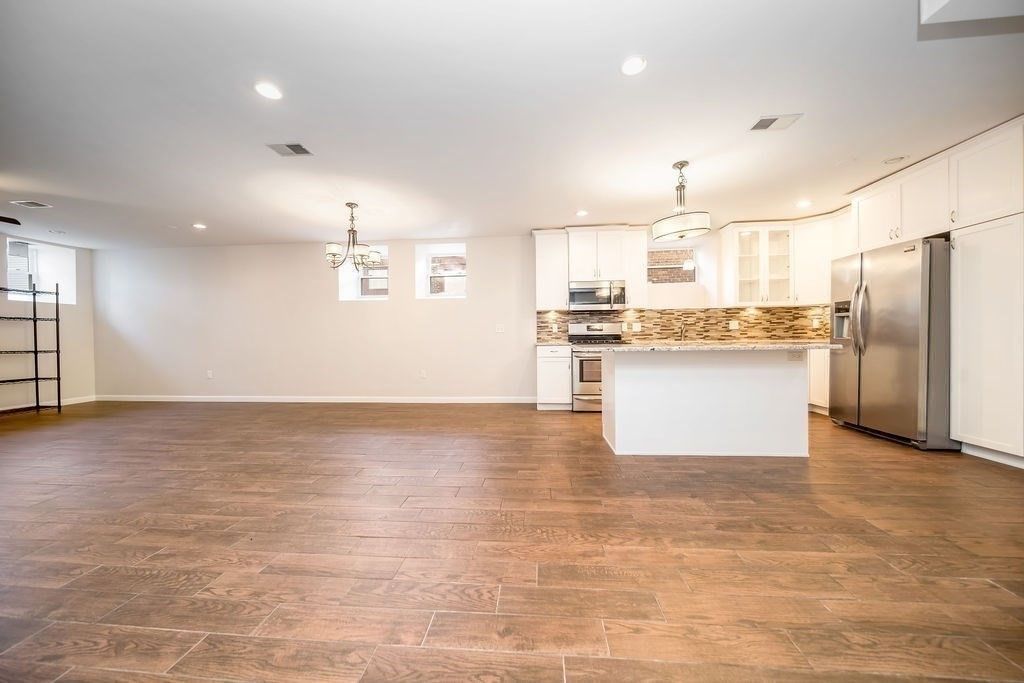 Chandelier, Empty room, Interior, Kitchen, Pendant Lights, Recessed Lighting, Stainless Steel Appliances, Wood Texture Flooring